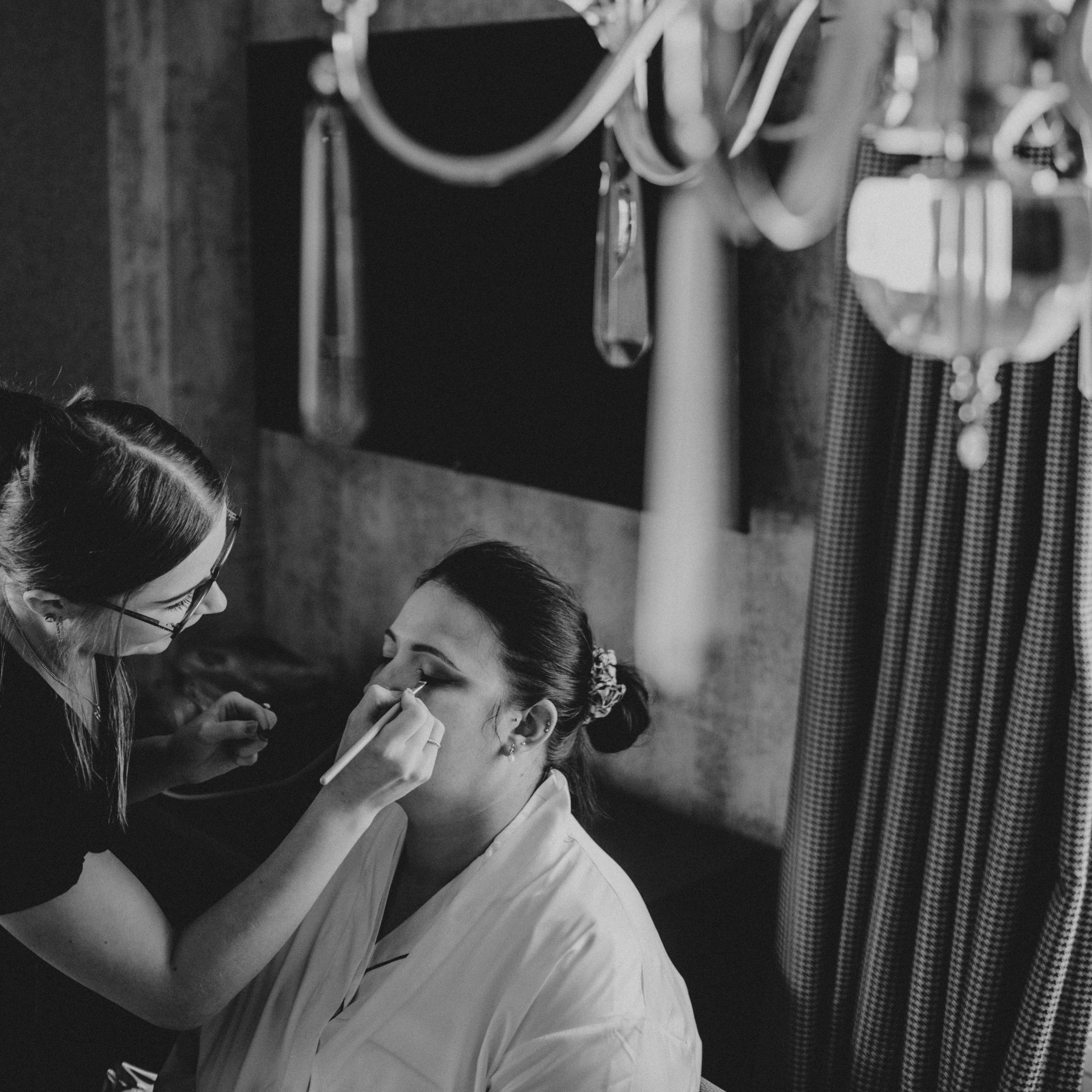Zeta applying bridal makeup to bride
